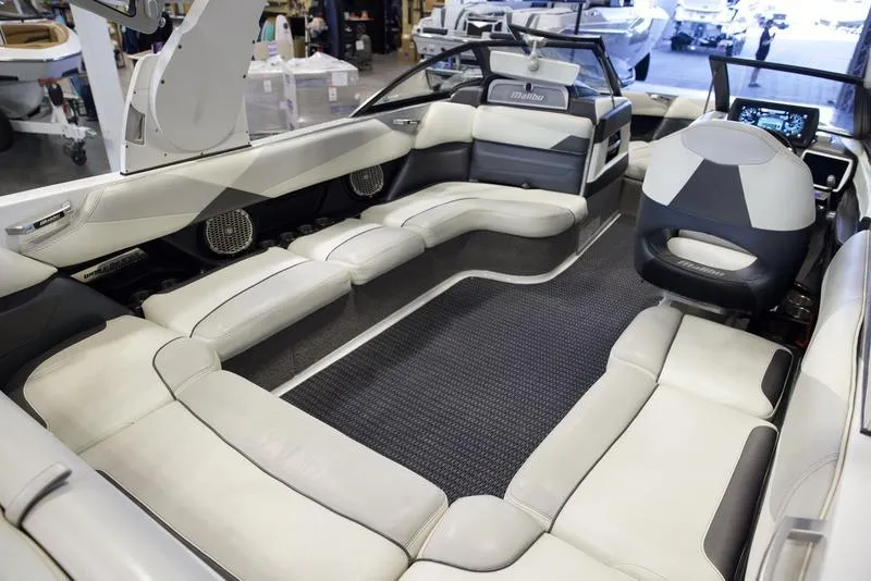 Slide: The Image of 2016 Malibu 23 LSV boat interior with spacious seating and modern dashboard. - 12