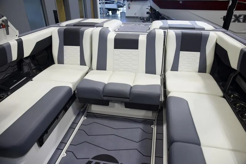 Slide: The Image of 2025 Malibu 22 MXZ boat interior with luxurious gray and white seating. - 10