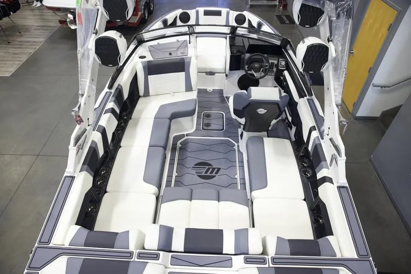 Slide: The Image of 2025 Malibu 22 MXZ boat interior with sleek, modern seating and advanced dashboard design. - 13