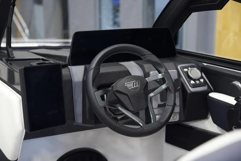 Slide: The Image of 2025 Malibu 22 MXZ boat dashboard with modern steering wheel and digital controls. - 15