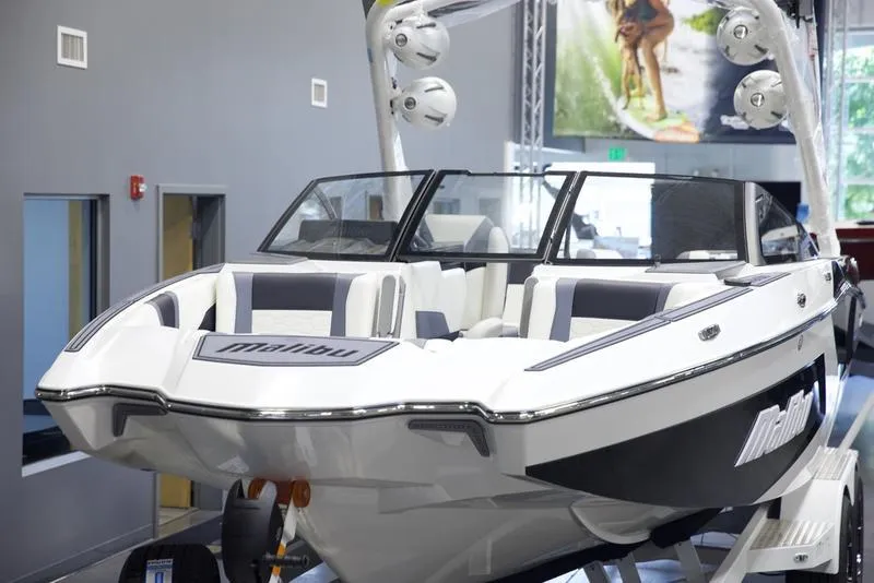 Slide: The Image of 2025 Malibu 22 MXZ boat displayed indoors, featuring sleek design and modern seating. - 7