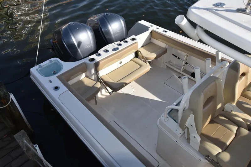 Slide: The Image of 2020 Sailfish 290 CC boat interior with dual engines, docked on water. - 11