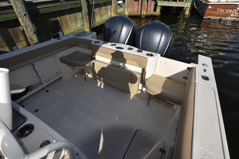 Slide: The Image of 2020 Sailfish 290 CC boat interior with seating and dual engines at dock. - 15