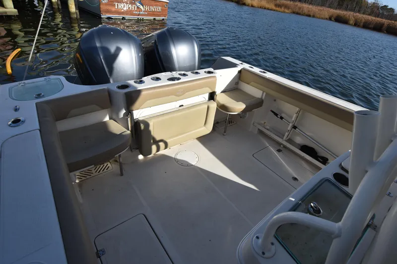 Slide: The Image of 2020 Sailfish 290 CC boat interior with dual engines, spacious seating, and fishing rod holders. - 16