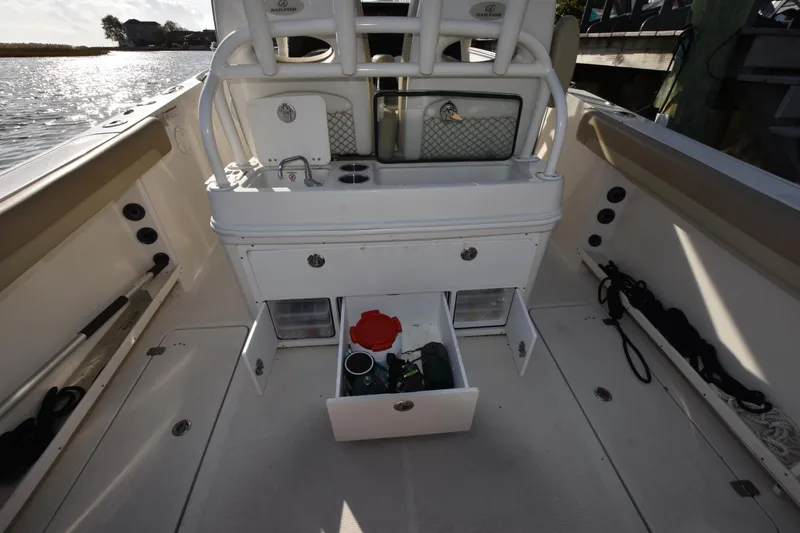 Slide: The Image of 2020 Sailfish 290 CC boat interior with open storage compartments and fishing gear. - 18