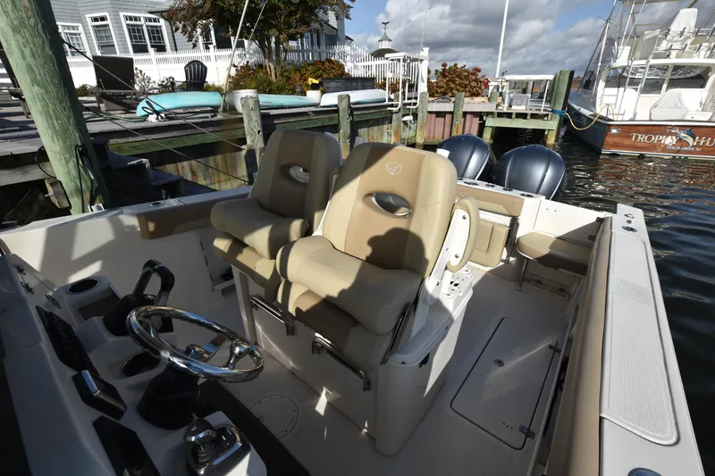 Slide: The Image of 2020 Sailfish 290 CC boat interior with dual seats at dock. - 21