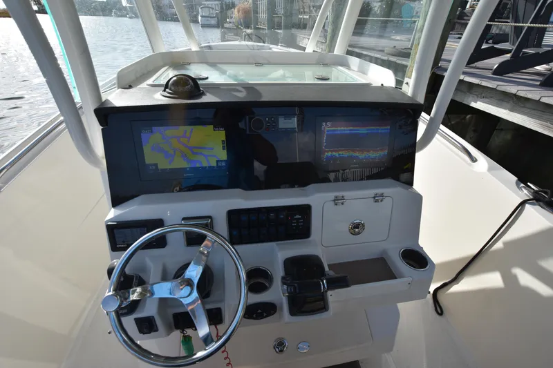 Slide: The Image of 2020 Sailfish 290 CC boat dashboard with navigation screens and steering wheel. - 24