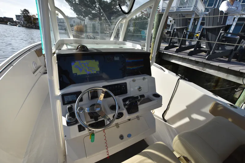 Slide: The Image of 2020 Sailfish 290 CC boat cockpit with steering wheel and navigation system. - 26
