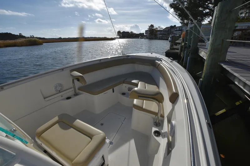 Slide: The Image of 2020 Sailfish 290 CC boat interior with seating, docked by a scenic waterfront. - 28