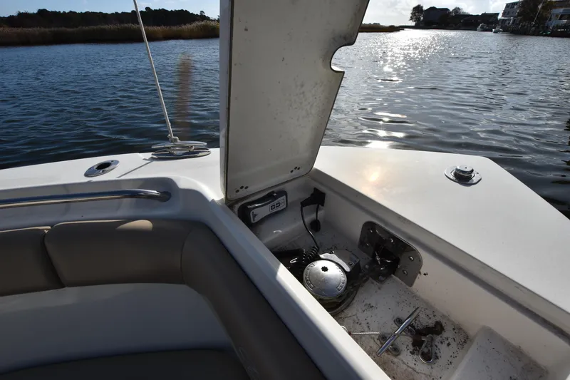 Slide: The Image of 2020 Sailfish 290 CC boat interior with open storage compartment by the water. - 30