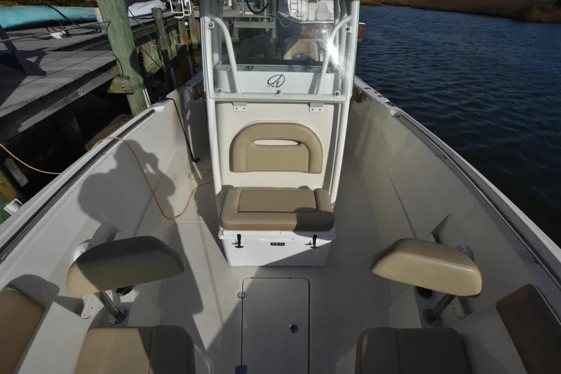 Slide: The Image of 2020 Sailfish 290 CC boat interior with seating, docked by the water. - 31