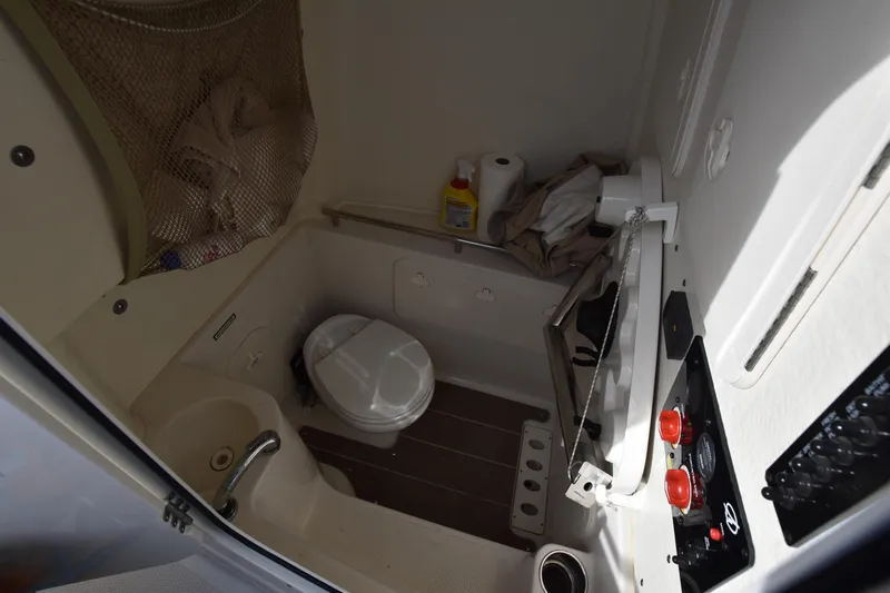 Slide: The Image of 2020 Sailfish 290 CC boat bathroom with toilet, sink, and storage. - 32