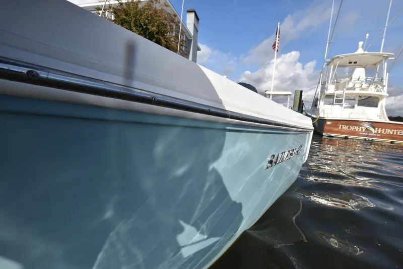 Slide: The Image of 2020 Sailfish 290 CC boat docked in marina, sunny day, calm water reflections. - 36