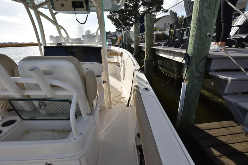 Slide: The Image of 2020 Sailfish 290 CC boat docked, featuring spacious deck and seating area. - 39