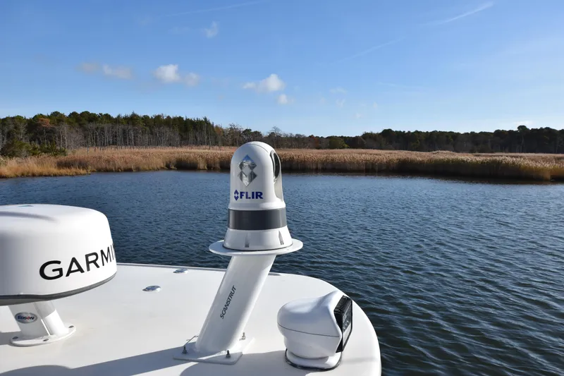 Slide: The Image of Sailfish 290 CC boat with Garmin and FLIR equipment on a calm lake, 2020 model. - 9