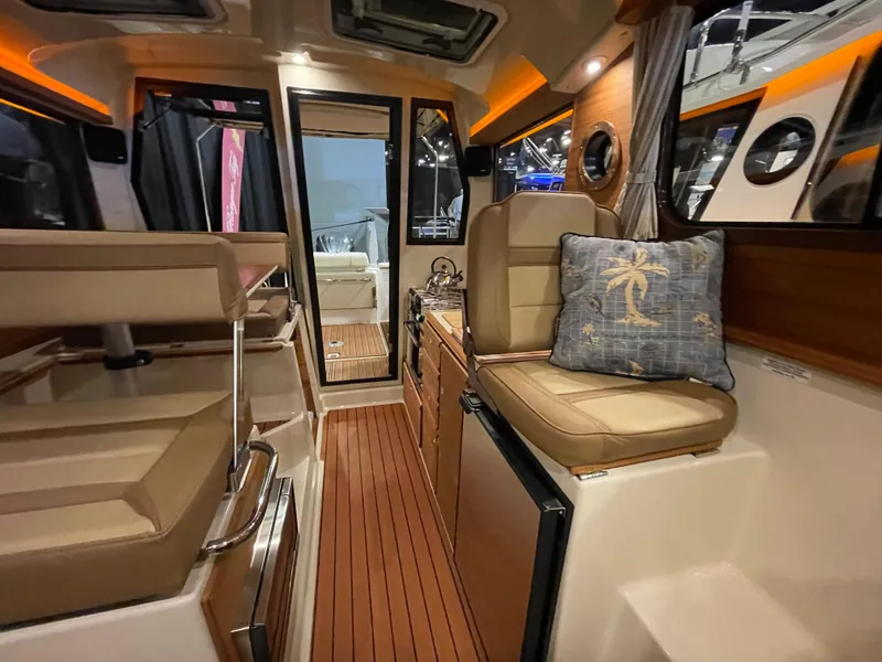 Slide: The Image of Interior of 2025 Ranger Tugs R-27 boat with modern seating and wood flooring. - 10