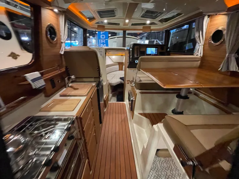 Slide: The Image of 2025 Ranger Tugs R-27 interior with modern kitchen and dining area. - 4