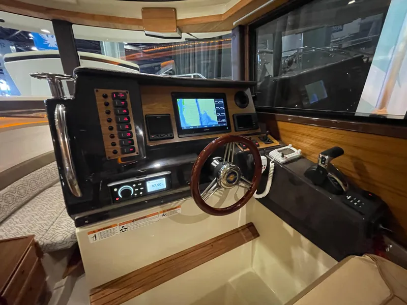 Slide: The Image of 2025 Ranger Tugs R-27 helm with navigation system and wooden steering wheel. - 5