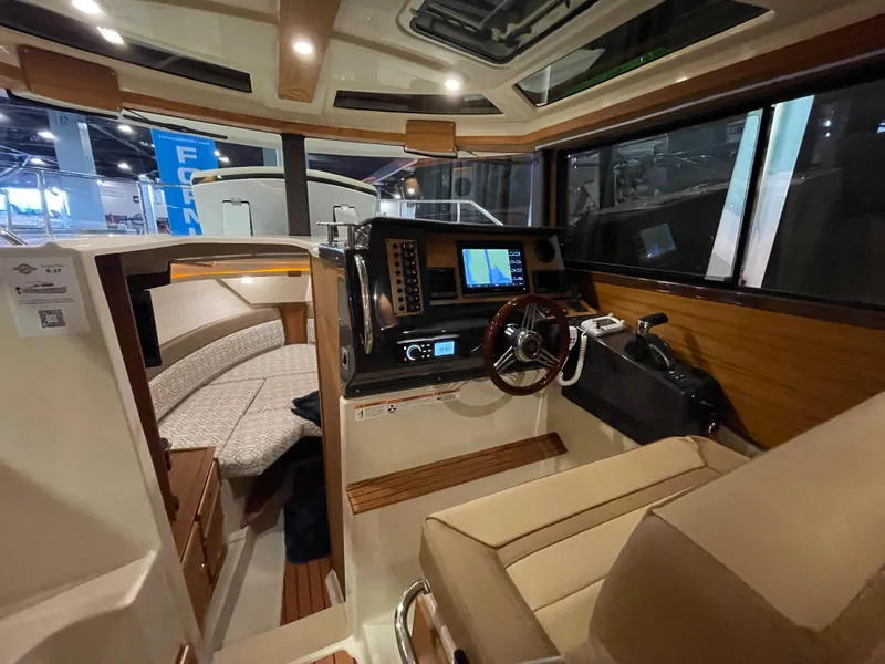 Slide: The Image of 2025 Ranger Tugs R-27 interior with helm, seating, and navigation equipment. - 6