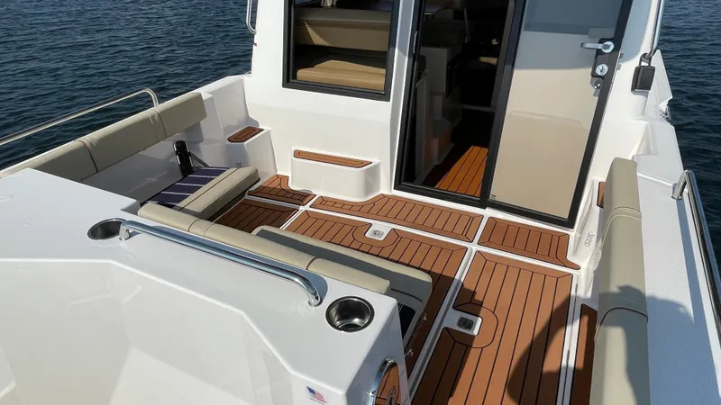 Slide: The Image of 2025 Ranger Tugs R-25 boat deck with seating and wood finish. - 11
