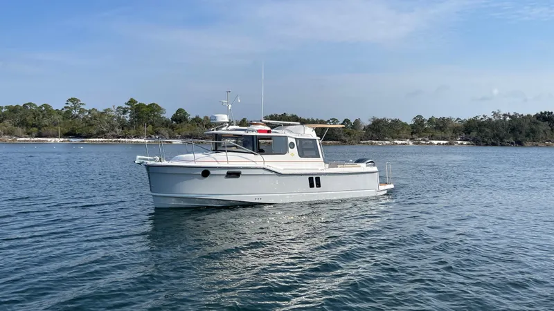 Slide: The Image of 2025 Ranger Tugs R-25 boat on calm water, scenic background. - 21