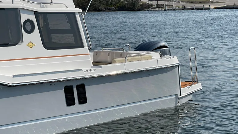 Slide: The Image of 2025 Ranger Tugs R-25 boat on water, side view, with outboard motor. - 24