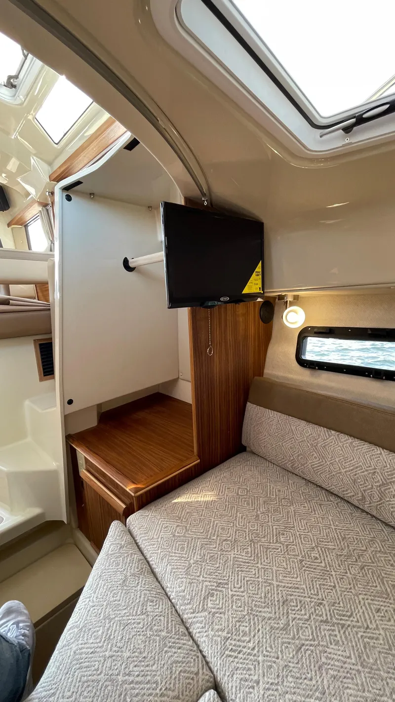 Slide: The Image of 2025 Ranger Tugs R-25 interior with cozy seating and mounted TV. - 31