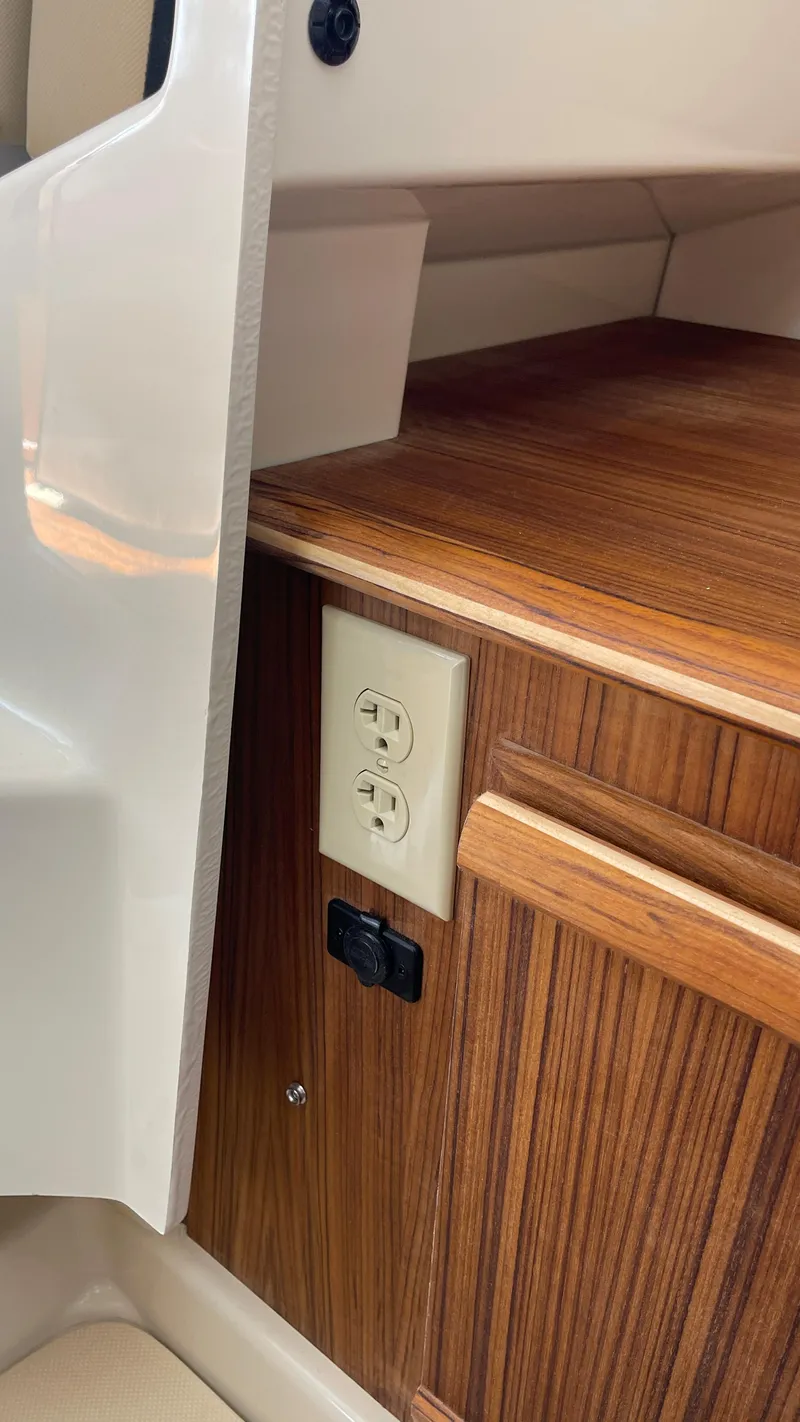 Slide: The Image of 2025 Ranger Tugs R-25 interior with wood finish and electrical outlet. - 34