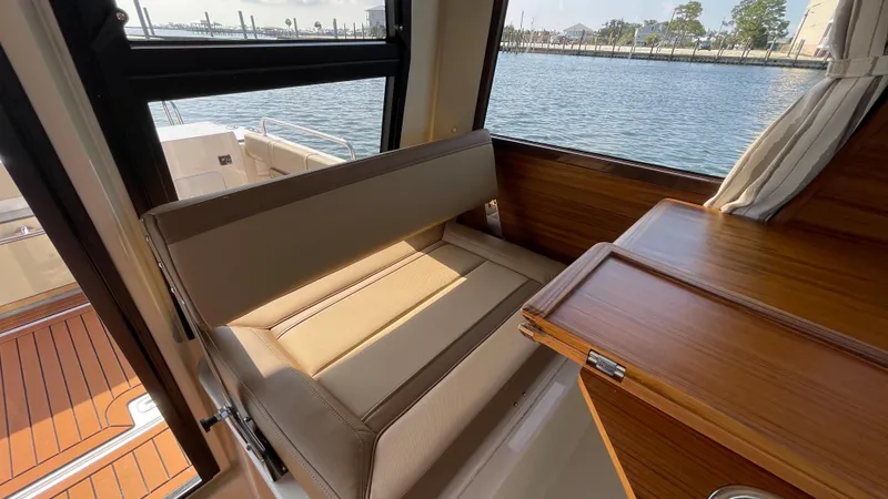 Slide: The Image of Interior of 2025 Ranger Tugs R-25 boat with seating and wooden table by the window. - 39