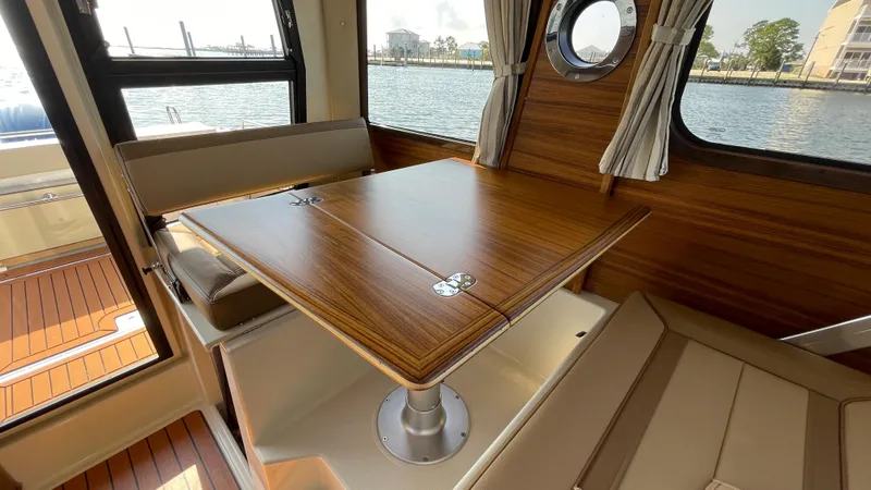 Slide: The Image of 2025 Ranger Tugs R-25 interior with wooden table and seating by the window. - 40