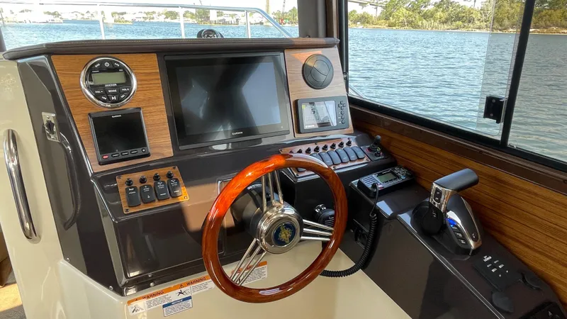 Slide: The Image of Helm of 2025 Ranger Tugs R-25 with wooden steering wheel and modern controls. - 42