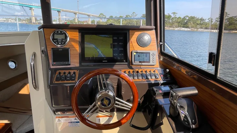 Slide: The Image of 2025 Ranger Tugs R-25 helm with modern navigation system and wooden steering wheel. - 48