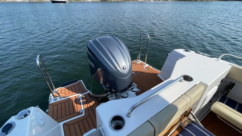 Slide: The Image of 2025 Ranger Tugs R-25 boat with outboard motor on calm water. - 8