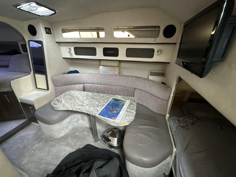 Slide: The Image of Interior of 1993 Sea Ray 300 boat with cozy seating and a mounted TV. - 12