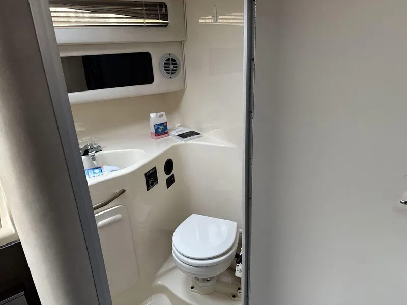 Slide: The Image of 1993 Sea Ray 300 boat bathroom with toilet, sink, and cleaning supplies. - 14