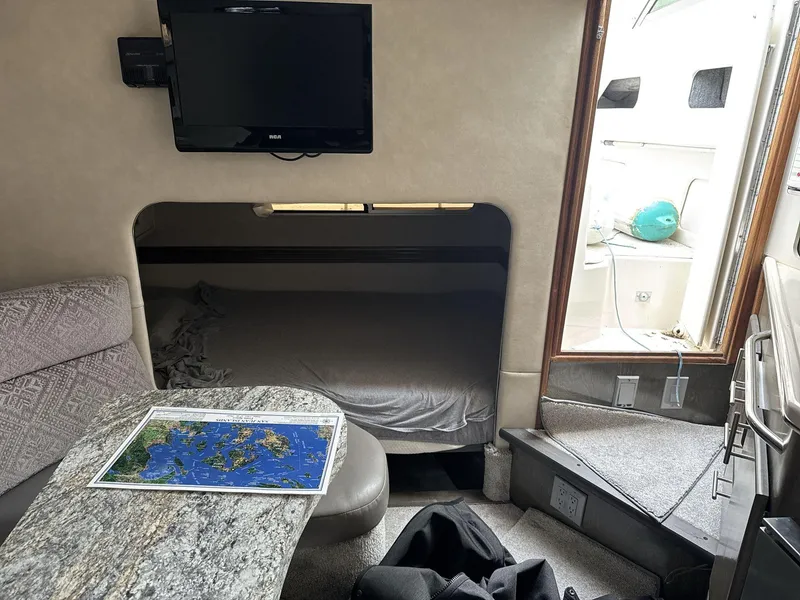 Slide: The Image of Interior of 1993 Sea Ray 300 boat with TV, map, and cozy seating area. - 15