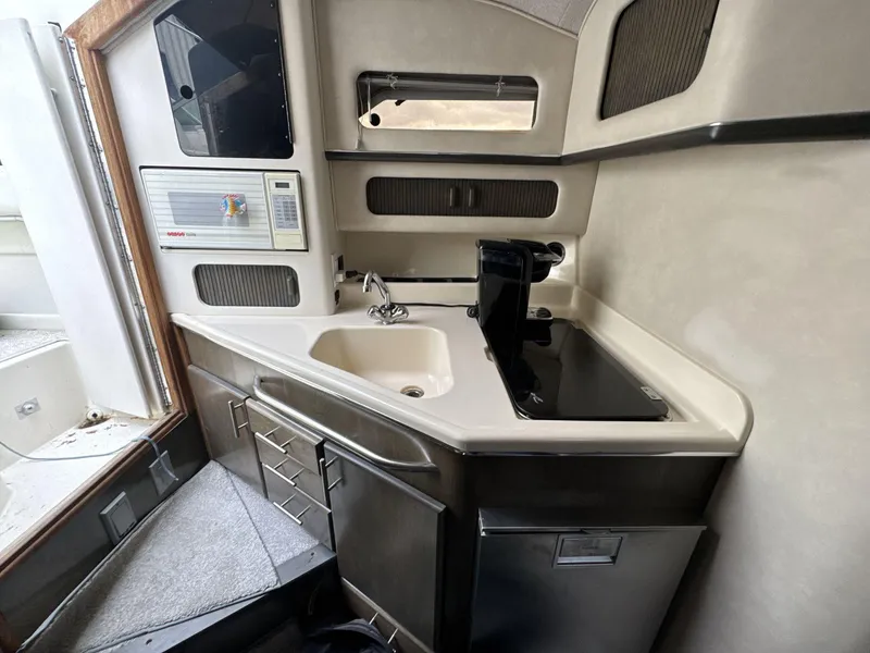 Slide: The Image of 1993 Sea Ray 300 boat interior kitchen with sink, stove, and microwave. - 16