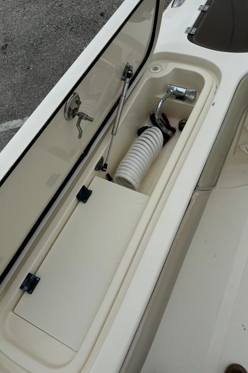 Slide: The Image of 2011 Scout 282 XSF boat storage compartment with hose and faucet. - 13