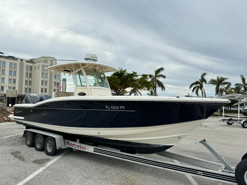Slide: The Image of 2011 Scout 282 XSF boat on trailer in parking lot with palm trees. - 3