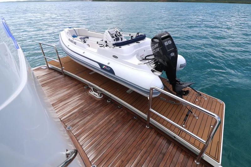 Slide: The Image of 2013 Cheoy Lee Bravo yacht with tender on wooden deck, ocean backdrop. - 17