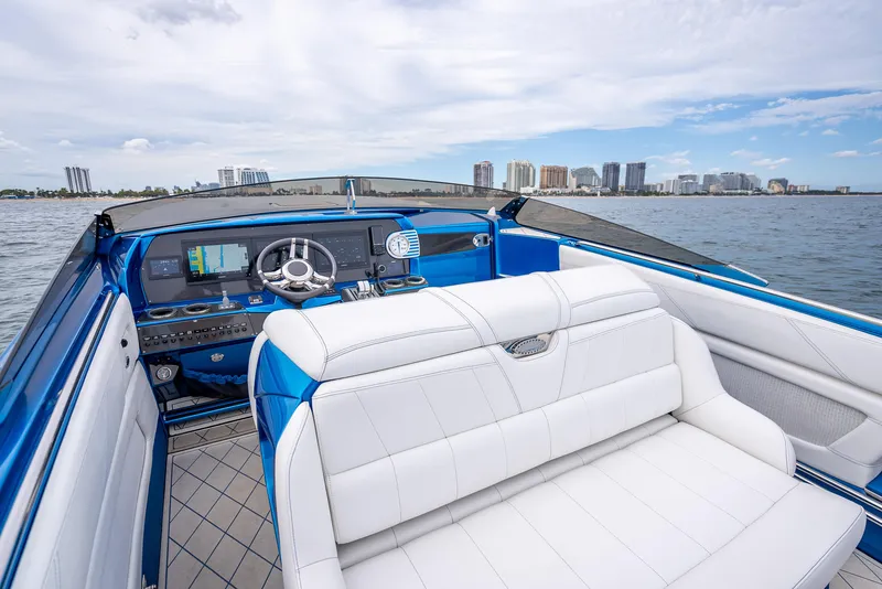 Slide: The Image of 2024 Nor-Tech 360 Monte Carlo Flyer boat interior with white seating and city skyline view. - 7
