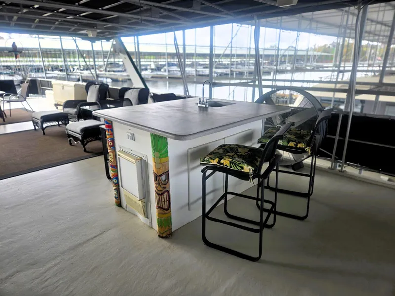 Slide: The Image of Spacious 1996 Sumerset houseboat interior with tiki-themed bar and marina view. - 8