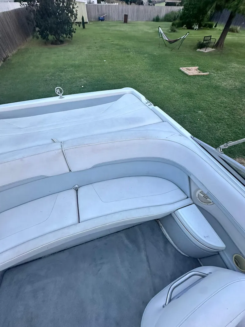 Slide: The Image of 1998 Cobalt 252 boat interior with white seating in a grassy backyard. - 10