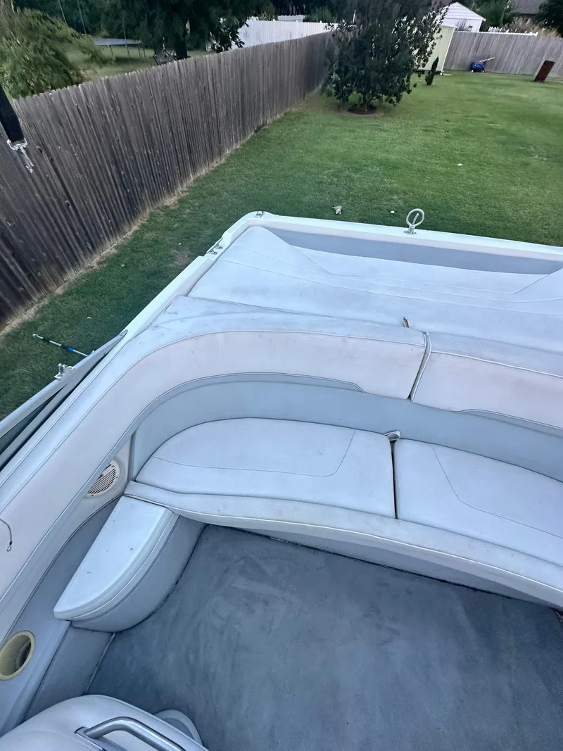 Slide: The Image of Interior of a 1998 Cobalt 252 boat with white seating and green lawn background. - 11