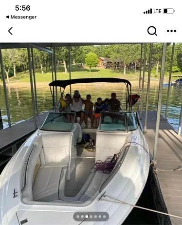 Slide: The Image of 1998 Cobalt 252 boat docked with people onboard, surrounded by a scenic lake view. - 14