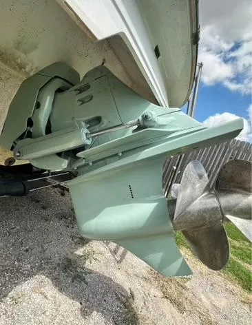 Slide: The Image of 1998 Cobalt 252 boat outdrive and propeller on gravel surface. - 16