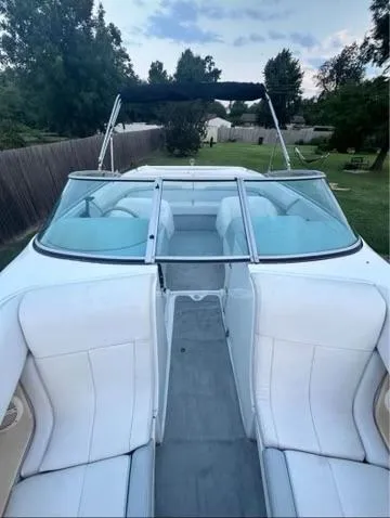 Slide: The Image of 1998 Cobalt 252 boat with white seating and canopy, parked outdoors. - 2