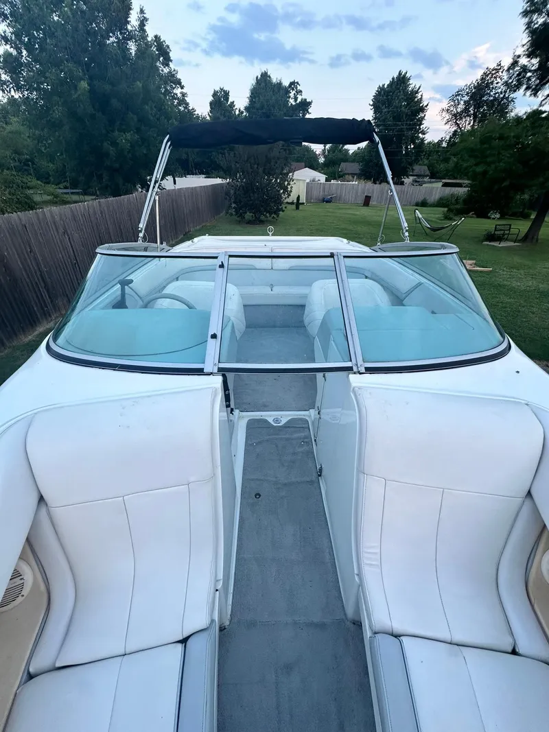 Slide: The Image of 1998 Cobalt 252 boat with white seating and canopy, parked on grass. - 5