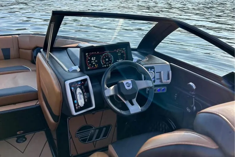 Slide: The Image of 2022 Malibu Wakesetter 23 LSV interior with modern dashboard and steering wheel on water. - 8