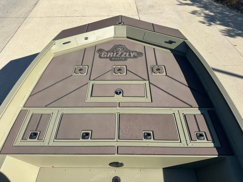 Slide: The Image of 2025 Tracker Grizzly 2072 CC boat deck with storage compartments and Grizzly logo. - 3